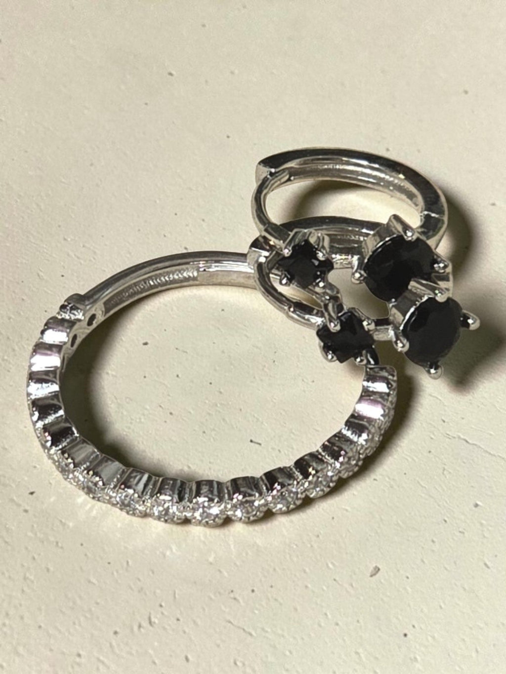 reveriebygemma adjustable sterling silver pavé eternity ring with clear cubic zirconia stones on a beige surface