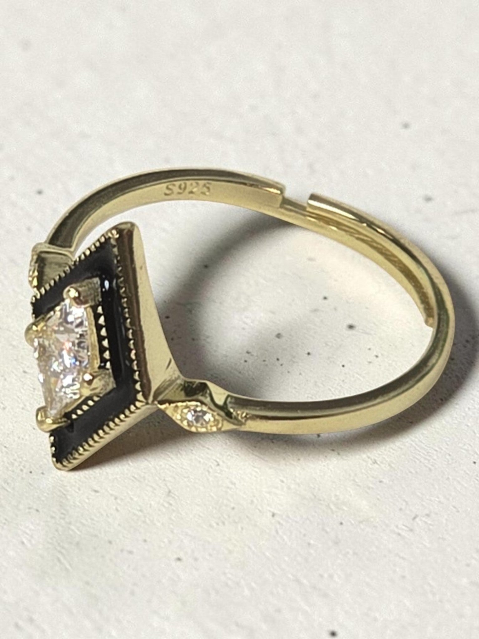 reveriebygemma gold plated sterling silver signet ring with black enamel, rhombus shape, and cubic zirconia stone.