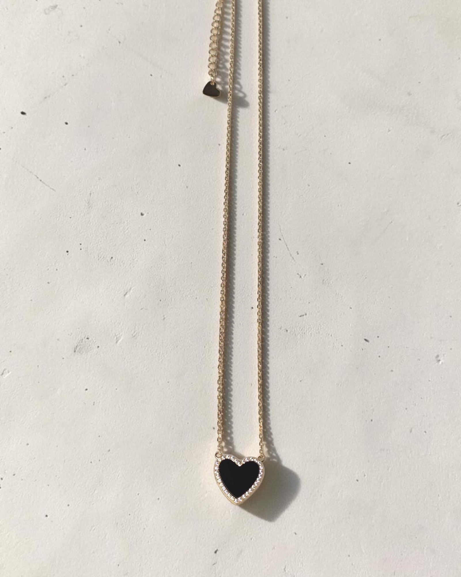 reveriebygemma black onyx heart pendant necklace with a cubic zirconia halo on a 14k gold plated sterling silver chain