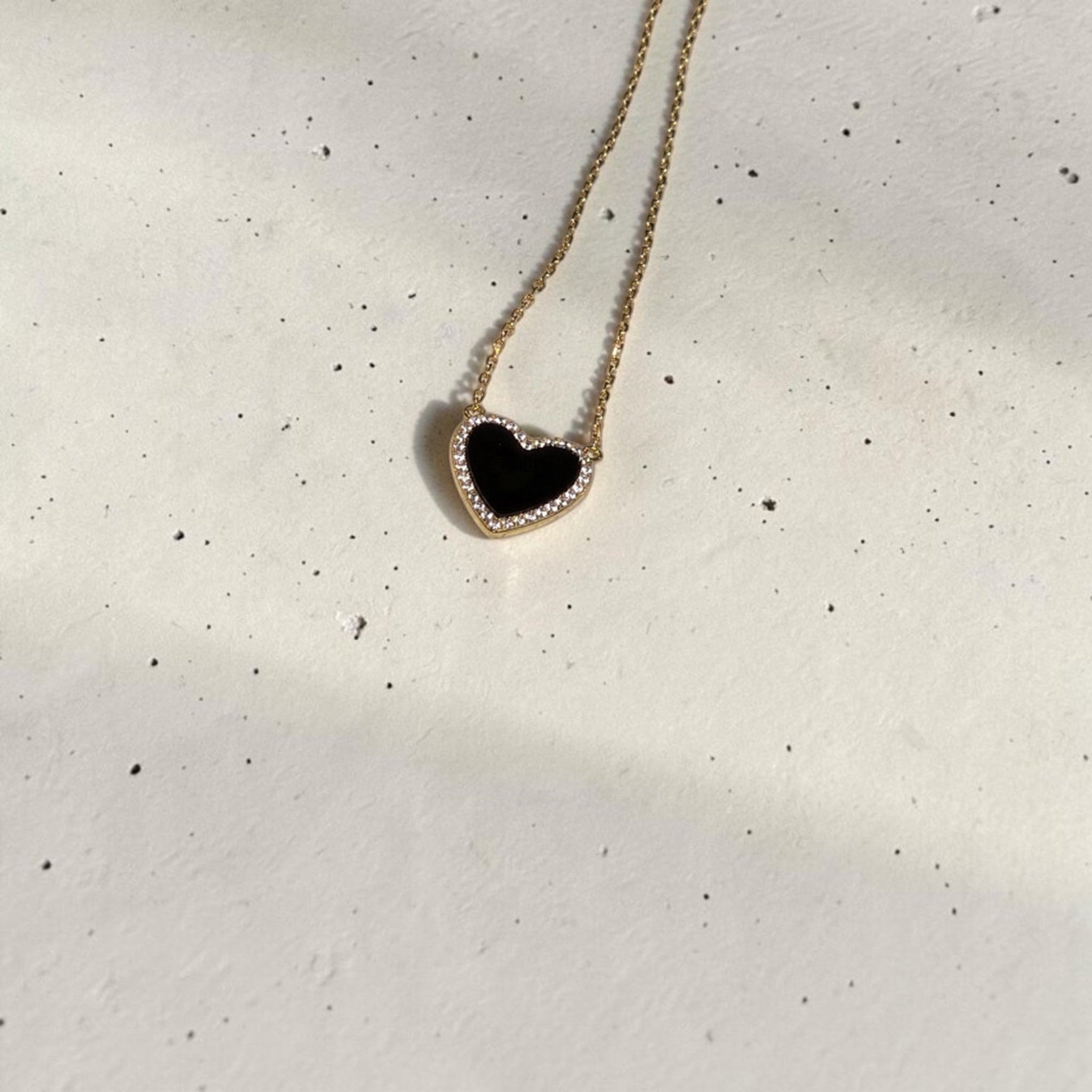 reveriebygemma black onyx heart pendant necklace with a cubic zirconia halo on a 14k gold plated sterling silver chain