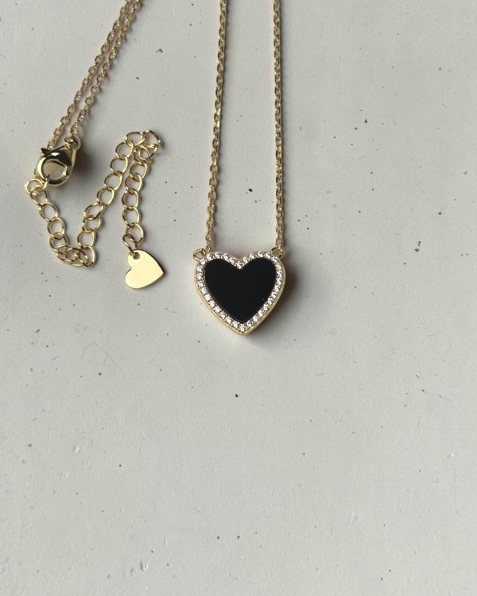 reveriebygemma black onyx heart pendant necklace with a cubic zirconia halo on a 14k gold plated sterling silver chain