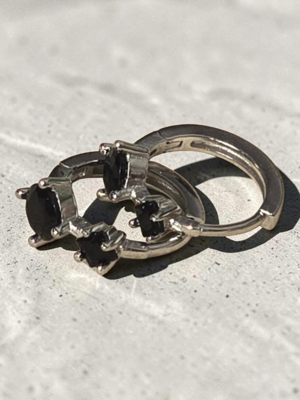 reveriebygemma sterling silver mini huggie hoops featuring two round-cut black onyx gemstones in a prong setting