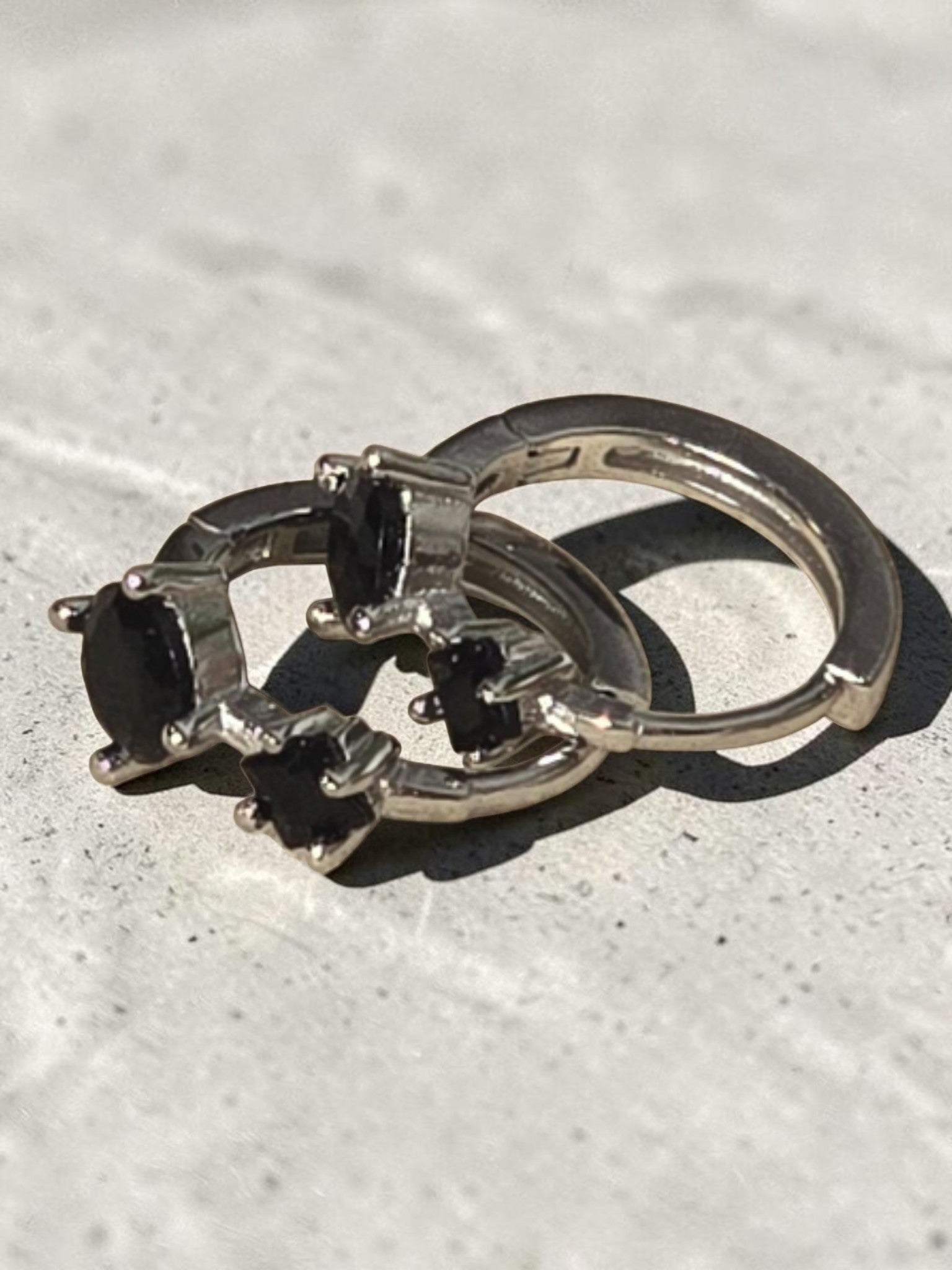 reveriebygemma sterling silver mini huggie hoops featuring two round-cut black onyx gemstones in a prong setting