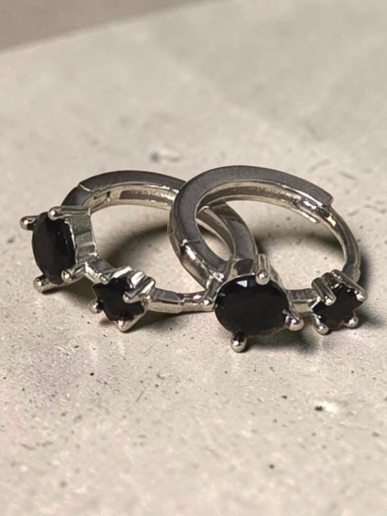 reveriebygemma sterling silver huggie hoops featuring two round-cut black onyx gemstones in a prong setting