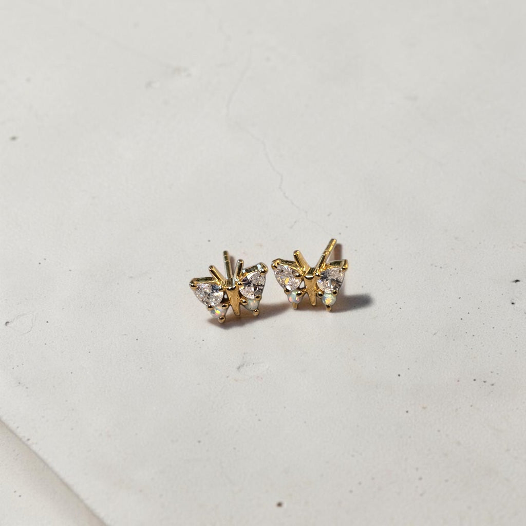 reveriebygemma butterfly stud earrings in 18kt gold vermeil with simulated diamonds and iridescent opals on a stone base