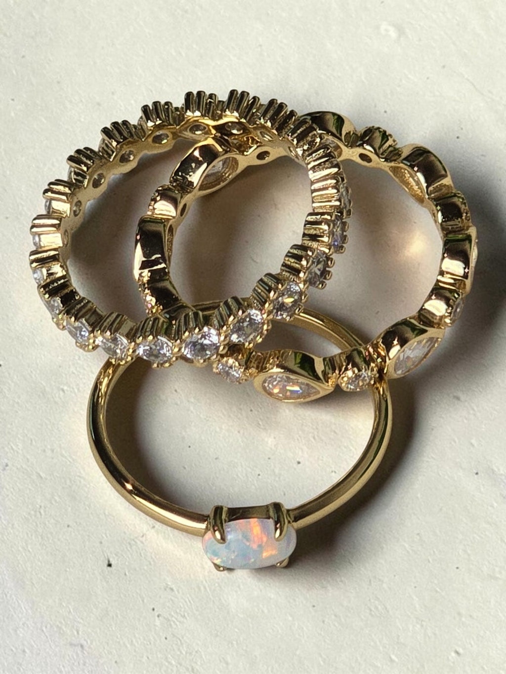 reveriebygemma fire opal and gold stacking rings featuring a lab-created opal stone and delicate gold-plated bands.
