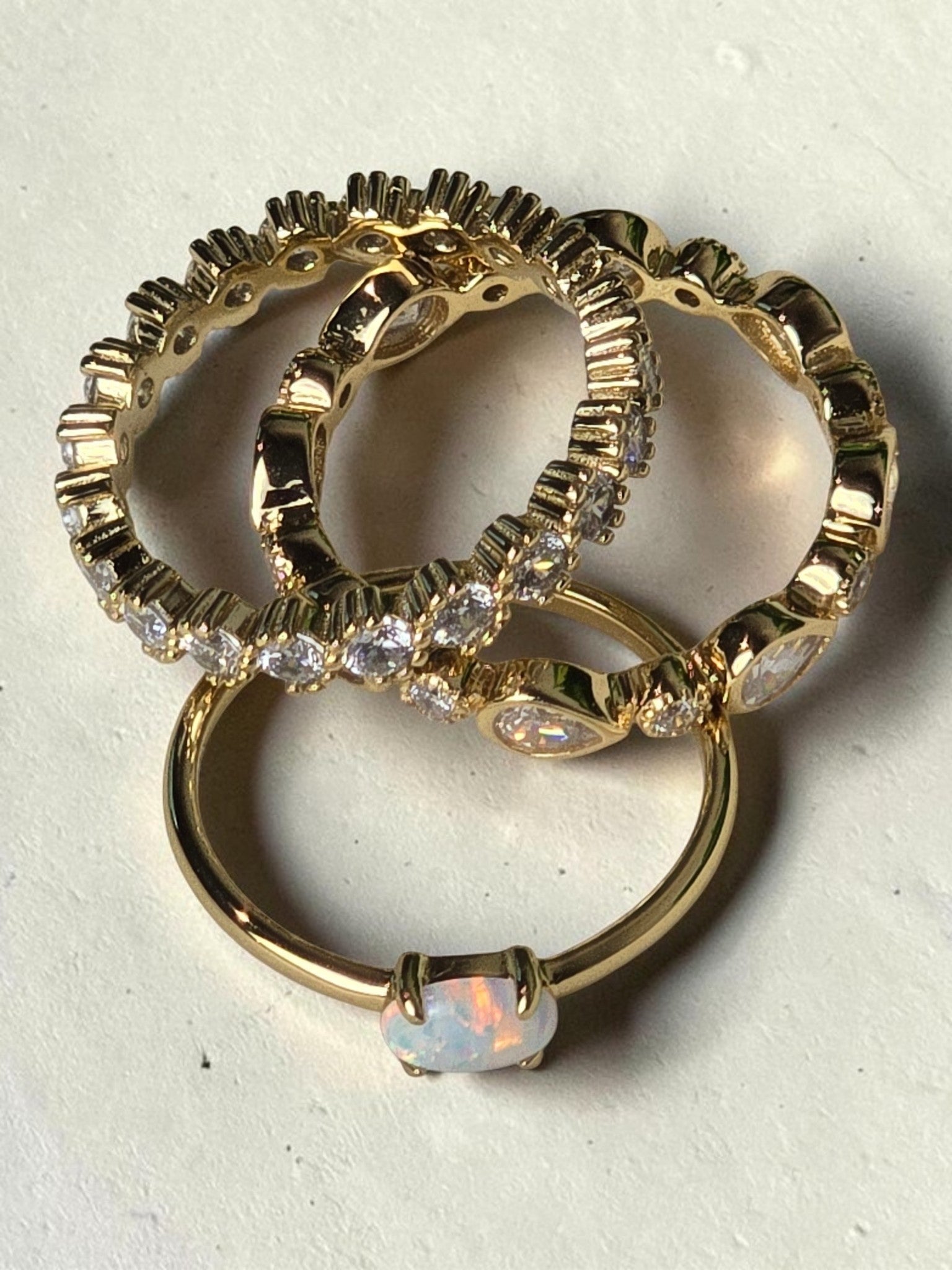 reveriebygemma fire opal and gold stacking rings featuring a lab-created opal stone and delicate gold-plated bands.