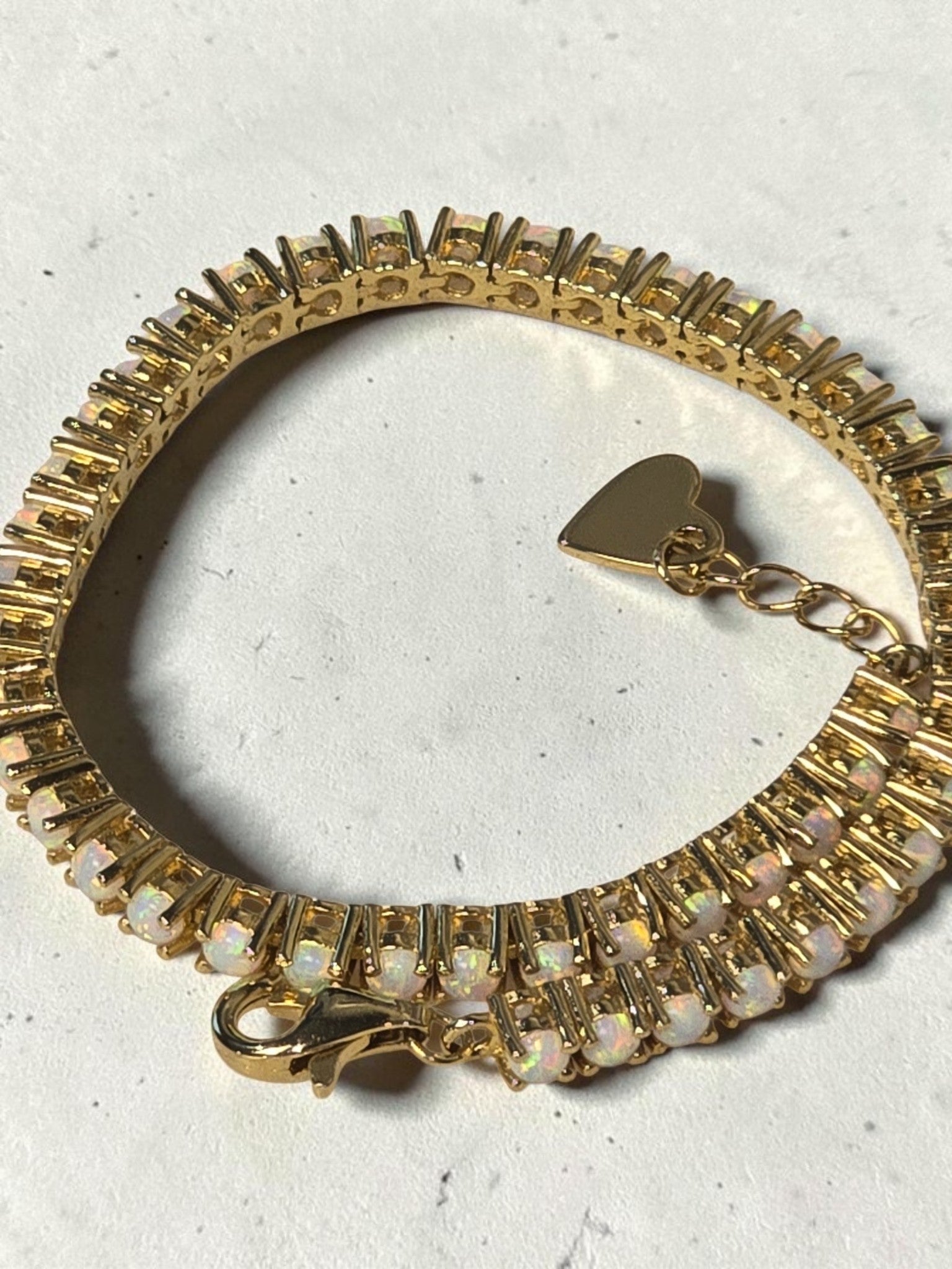 reveriebygemma fire opal tennis bracelet in 14kt gold plated sterling silver with a delicate heart charm accent