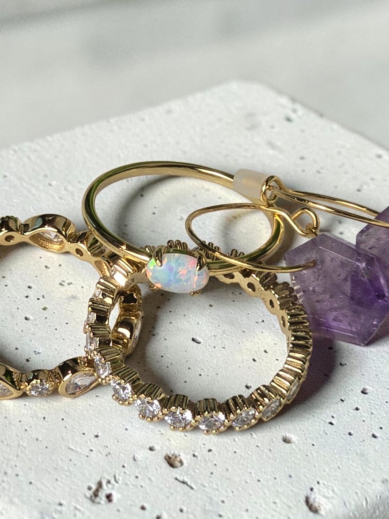 reveriebygemma fire opal stacking ring in 14kt gold plated silver, shown with matching gold and crystal jewelry.