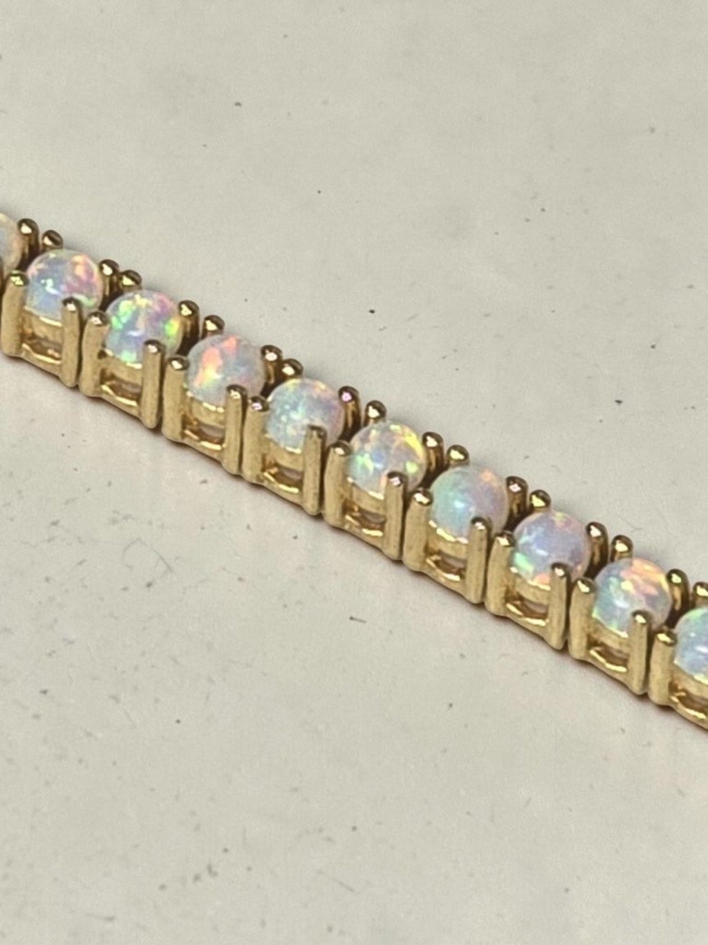reveriebygemma fire opal tennis bracelet in 14kt gold plated sterling silver with round prong-set iridescent stones