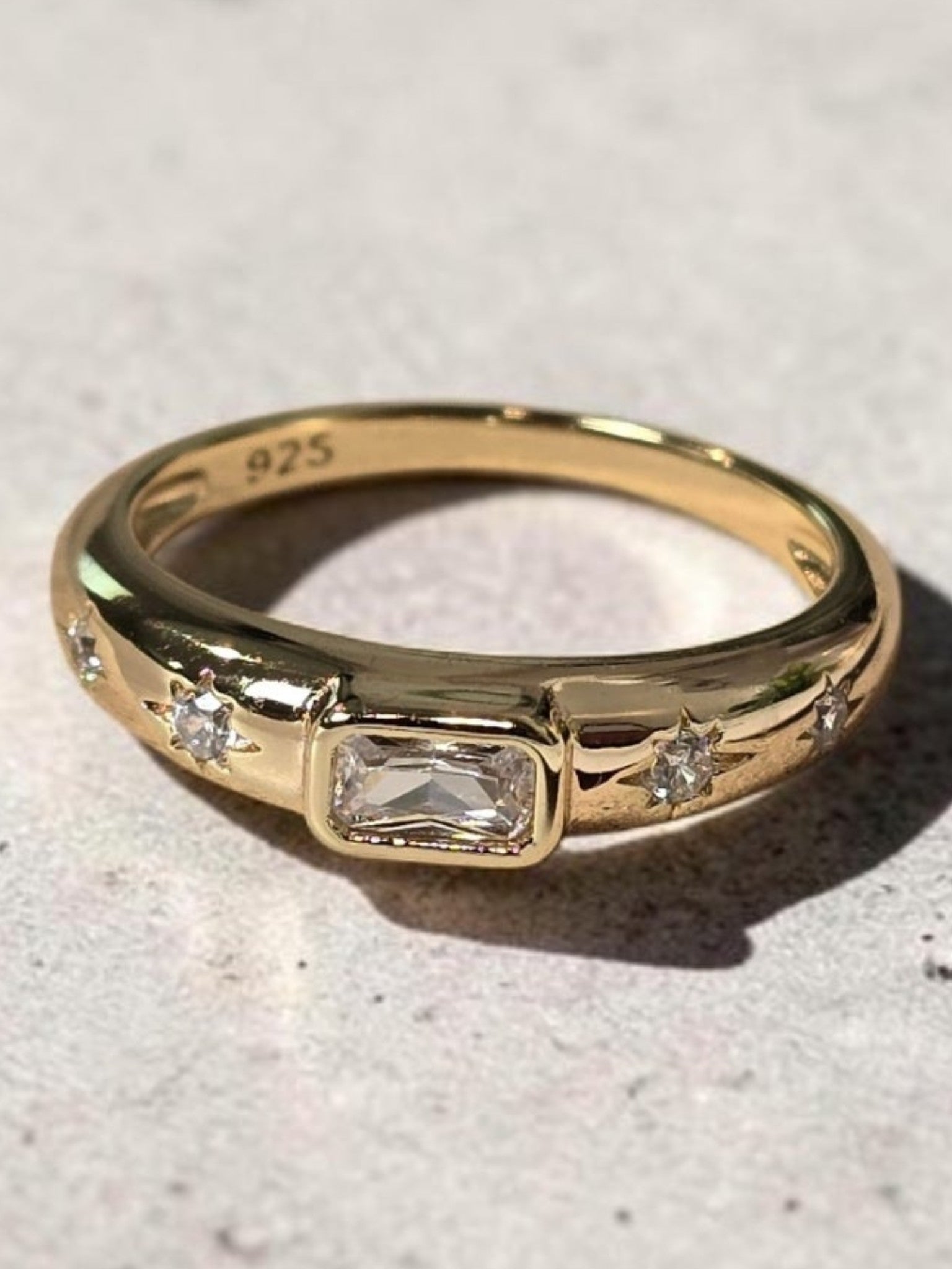 reveriebygemma 14kt gold plated sterling silver dome ring with a baguette CZ stone and starburst engravings