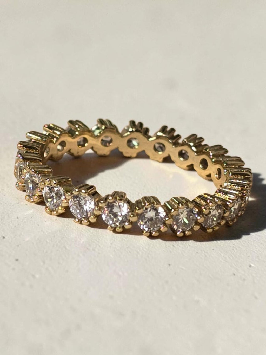 reveriebygemma 14kt gold plated sterling silver eternity band with bezel-set cubic zirconia stones and scalloped edges