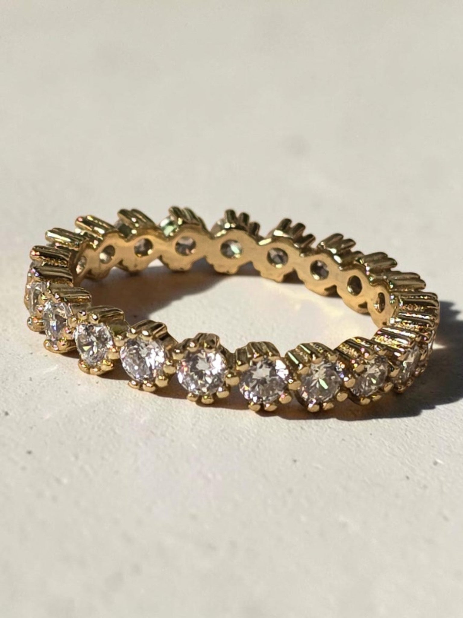 reveriebygemma 14kt gold plated sterling silver eternity band with bezel-set cubic zirconia stones and scalloped edges