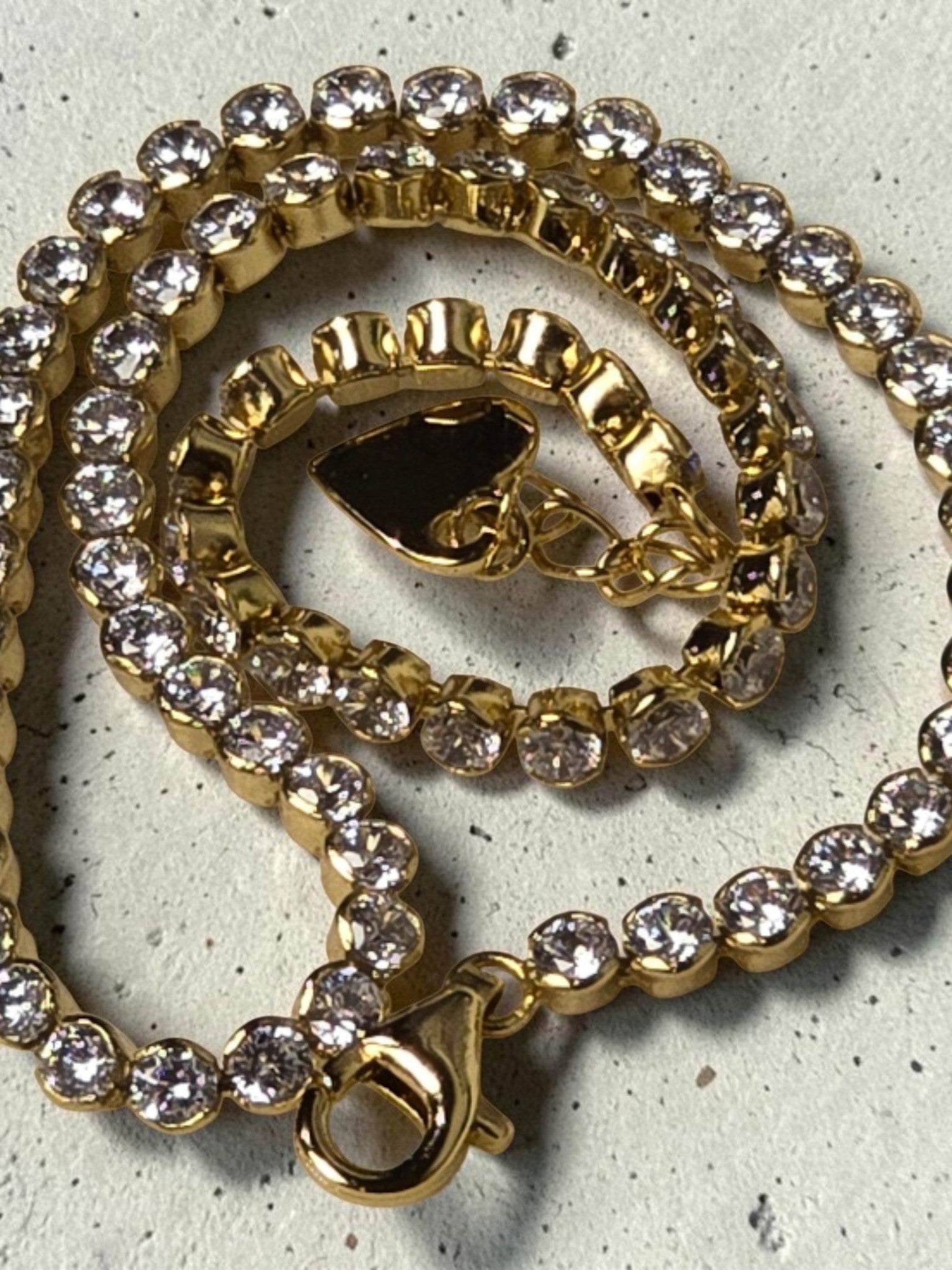 reveriebygemma 14kt gold plated sterling silver tennis anklet with round cubic zirconia stones and a heart charm.