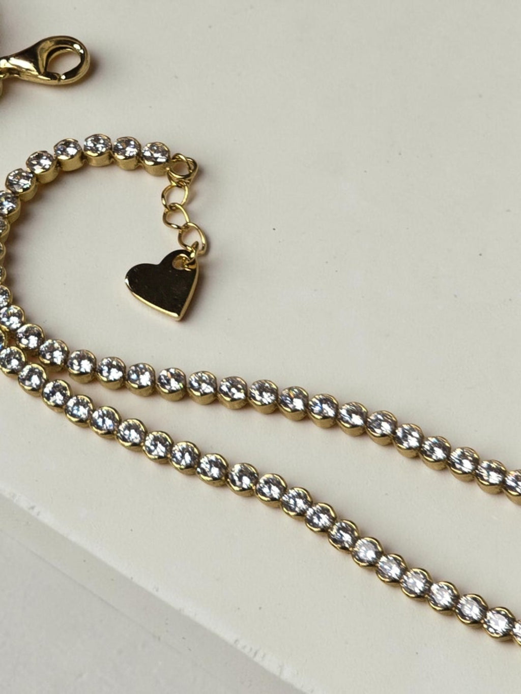 reveriebygemma 14kt gold plated sterling silver tennis anklet with cubic zirconia stones and a heart charm