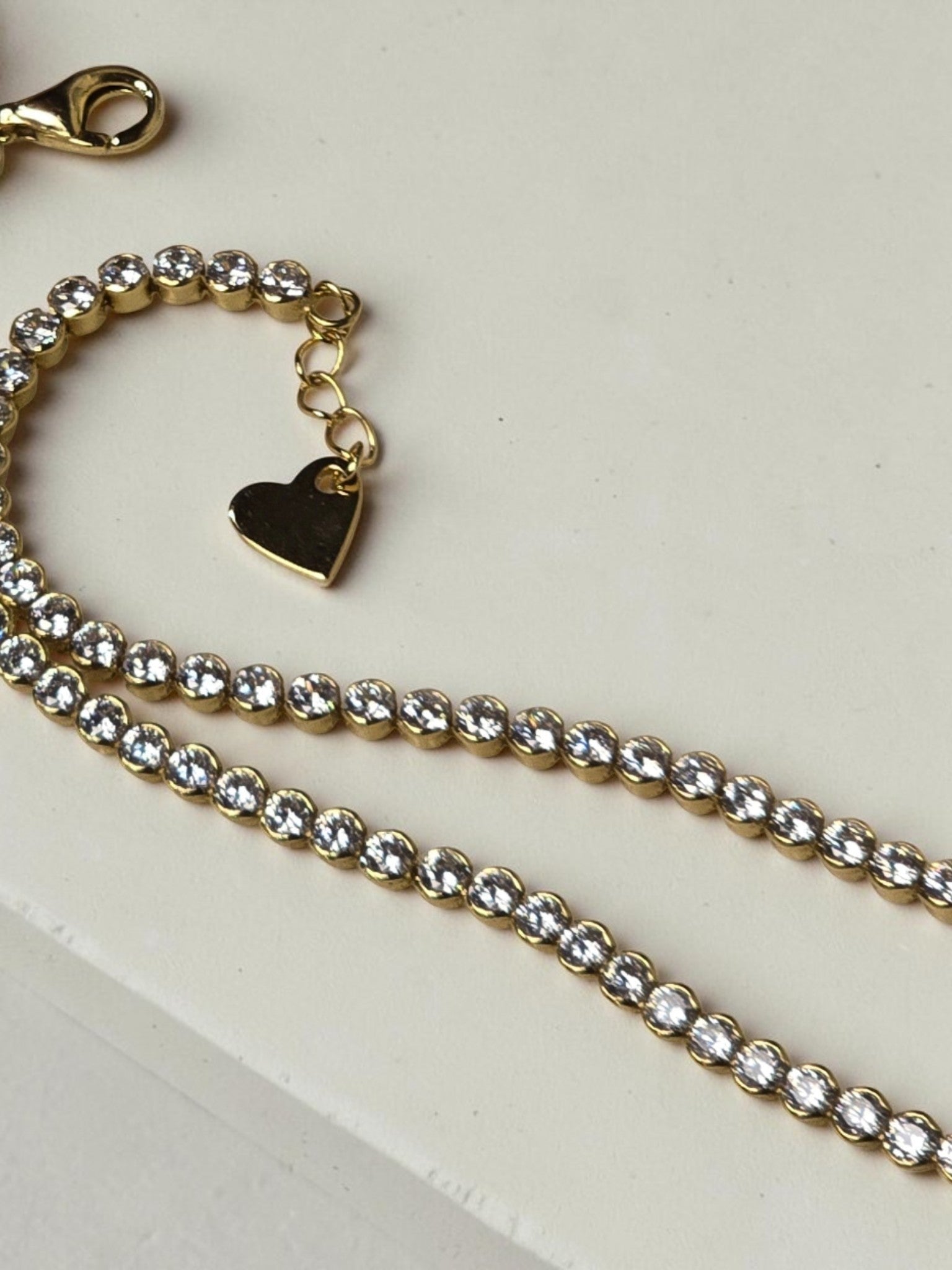 reveriebygemma 14kt gold plated sterling silver tennis anklet with cubic zirconia stones and a heart charm
