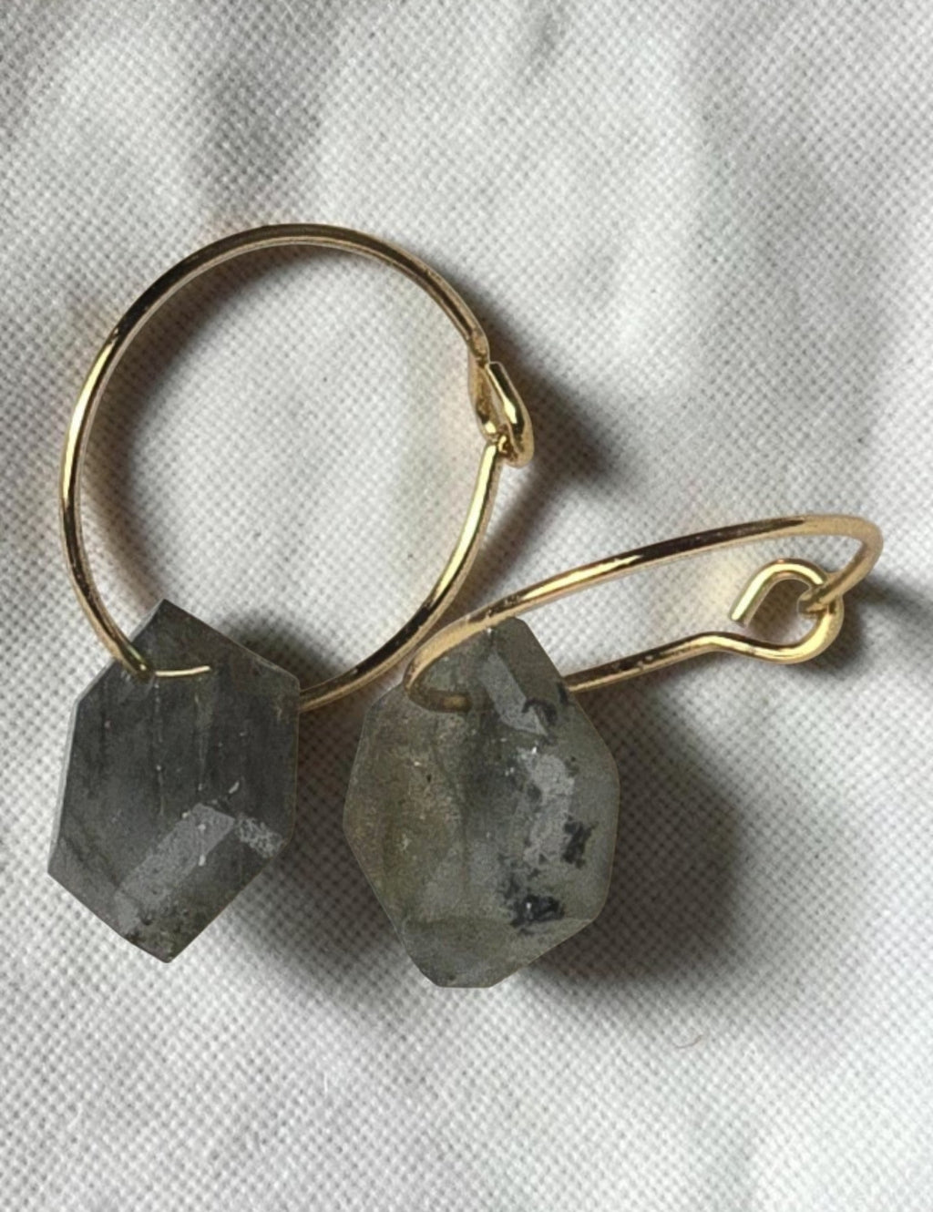 reveriebygemma gold huggie earrings with geometric labradorite gemstone drops on a white marble surface