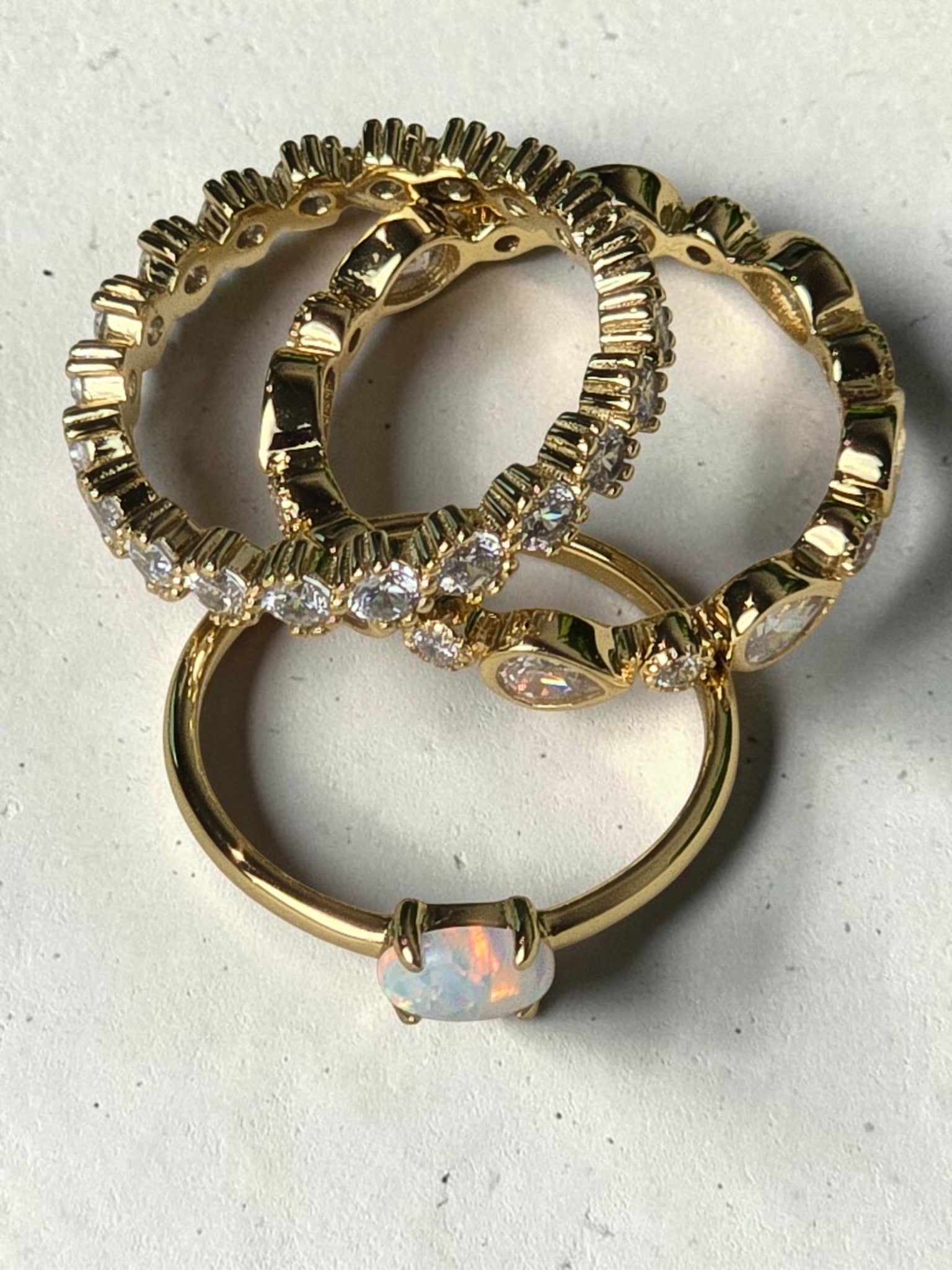 reveriebygemma gold plated stacking rings featuring pear and round bezel-set cubic zirconia and an opal solitaire