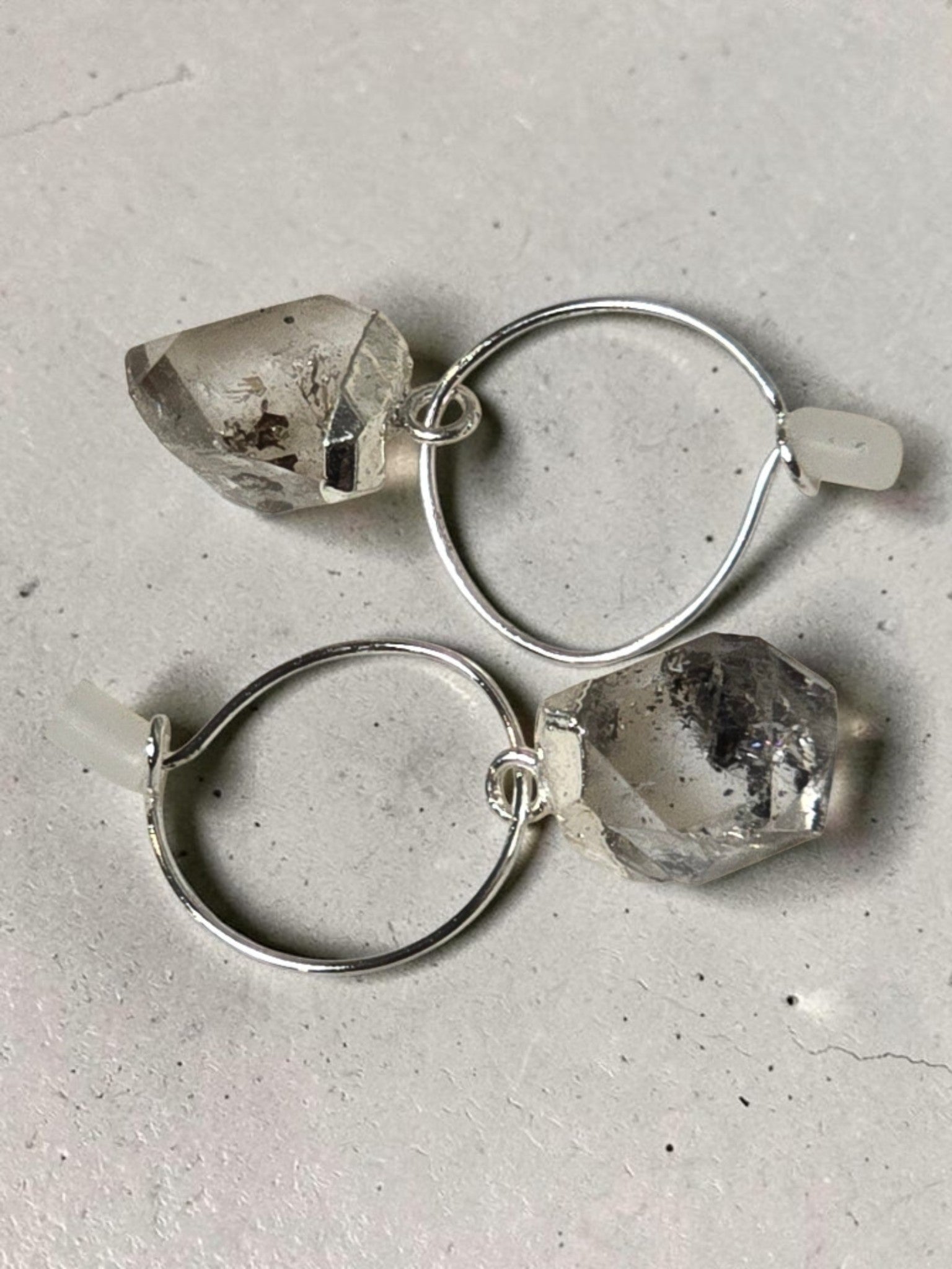 reveriebygemma sterling silver mini hoop earrings featuring raw-cut Herkimer diamond quartz crystals on a marble surface