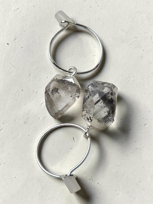 reveriebygemma sterling silver mini hoop earrings featuring raw-cut Herkimer diamond quartz crystals on a light surface