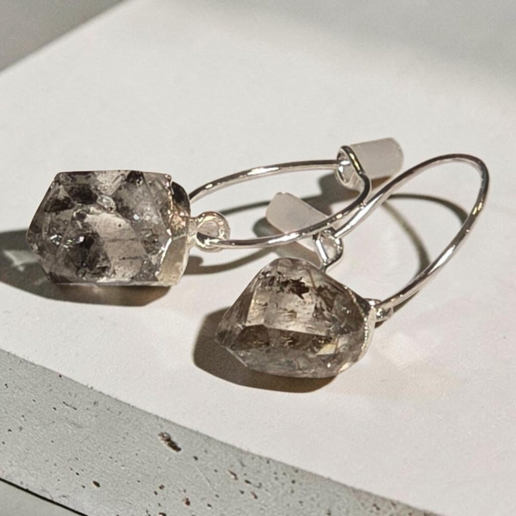 reveriebygemma sterling silver mini hoop earrings featuring raw-cut Herkimer diamond quartz crystals on a textured surface