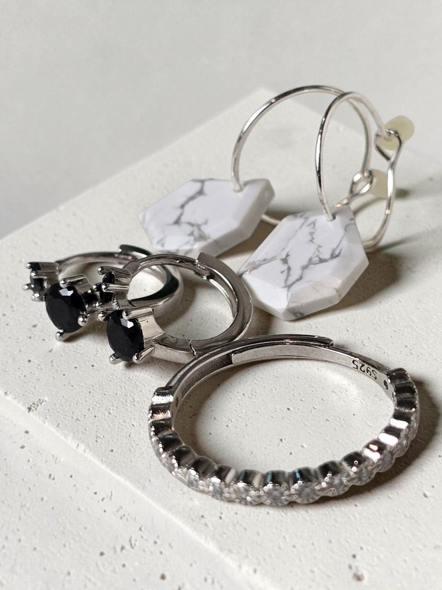 reveriebygemma geometric howlite and sterling silver huggie earrings paired with onyx hoops and a pavé stacking ring