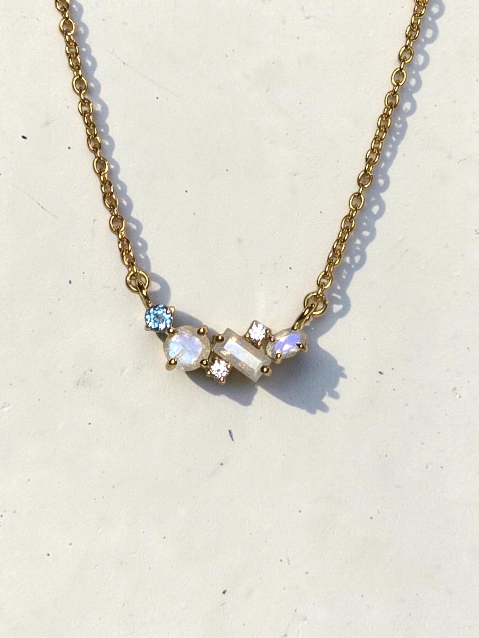reveriebygemma 18kt gold vermeil necklace featuring an asymmetric cluster of rainbow moonstone, London blue, and white topaz.