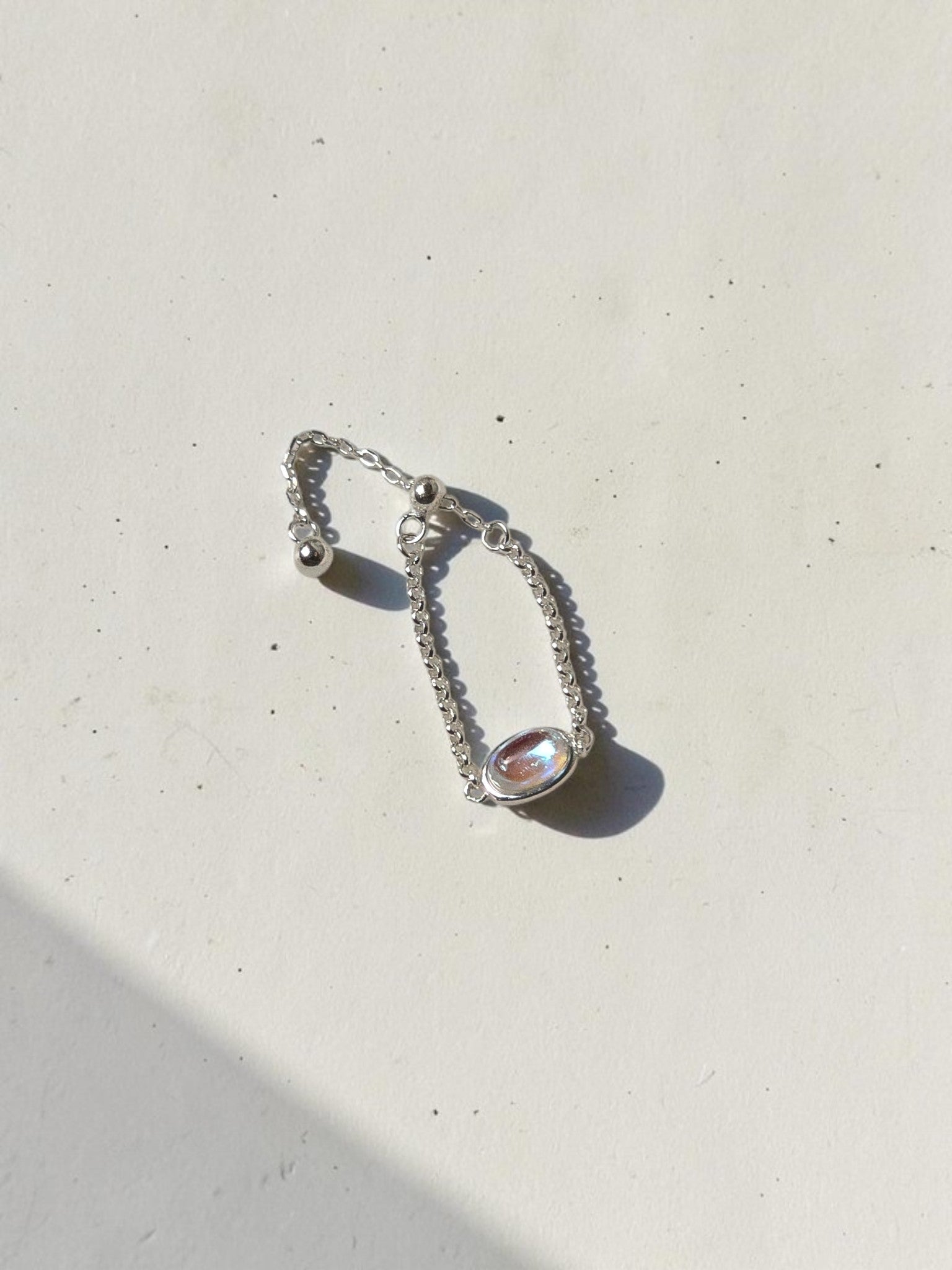 reveriebygemma adjustable 925 sterling silver chain ring featuring an oval simulated moonstone with a blue flash