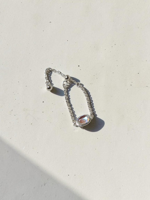 reveriebygemma adjustable 925 sterling silver chain ring featuring an oval simulated moonstone with a blue flash
