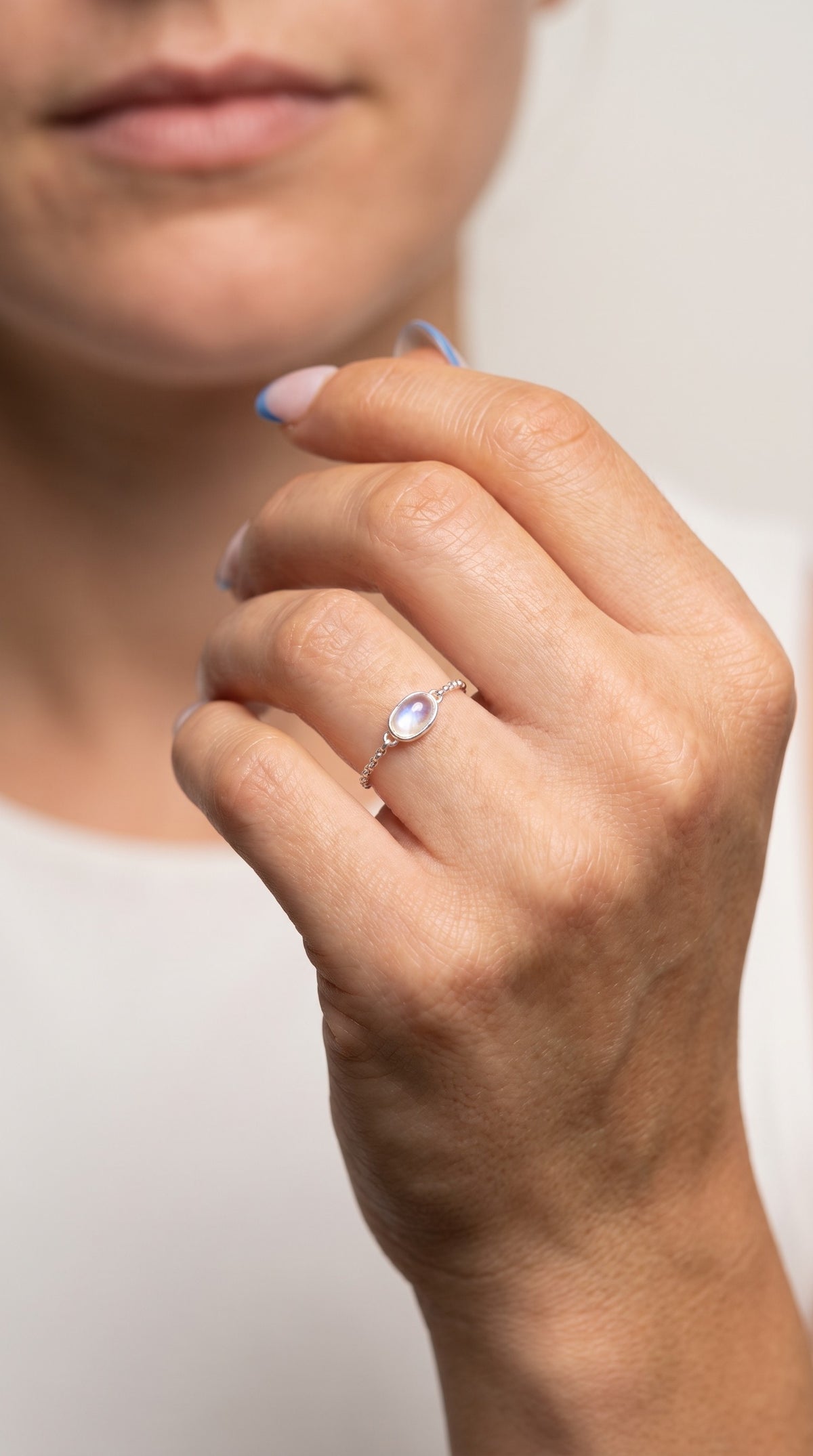 reveriebygemma adjustable 925 sterling silver chain ring featuring an oval simulated moonstone with a blue flash