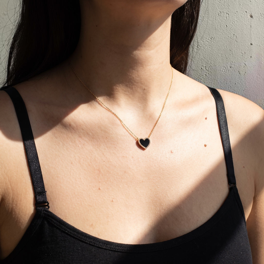 reveriebygemma Amoret heart pendant necklace featuring a black onyx stone with a CZ pave halo on a gold chain