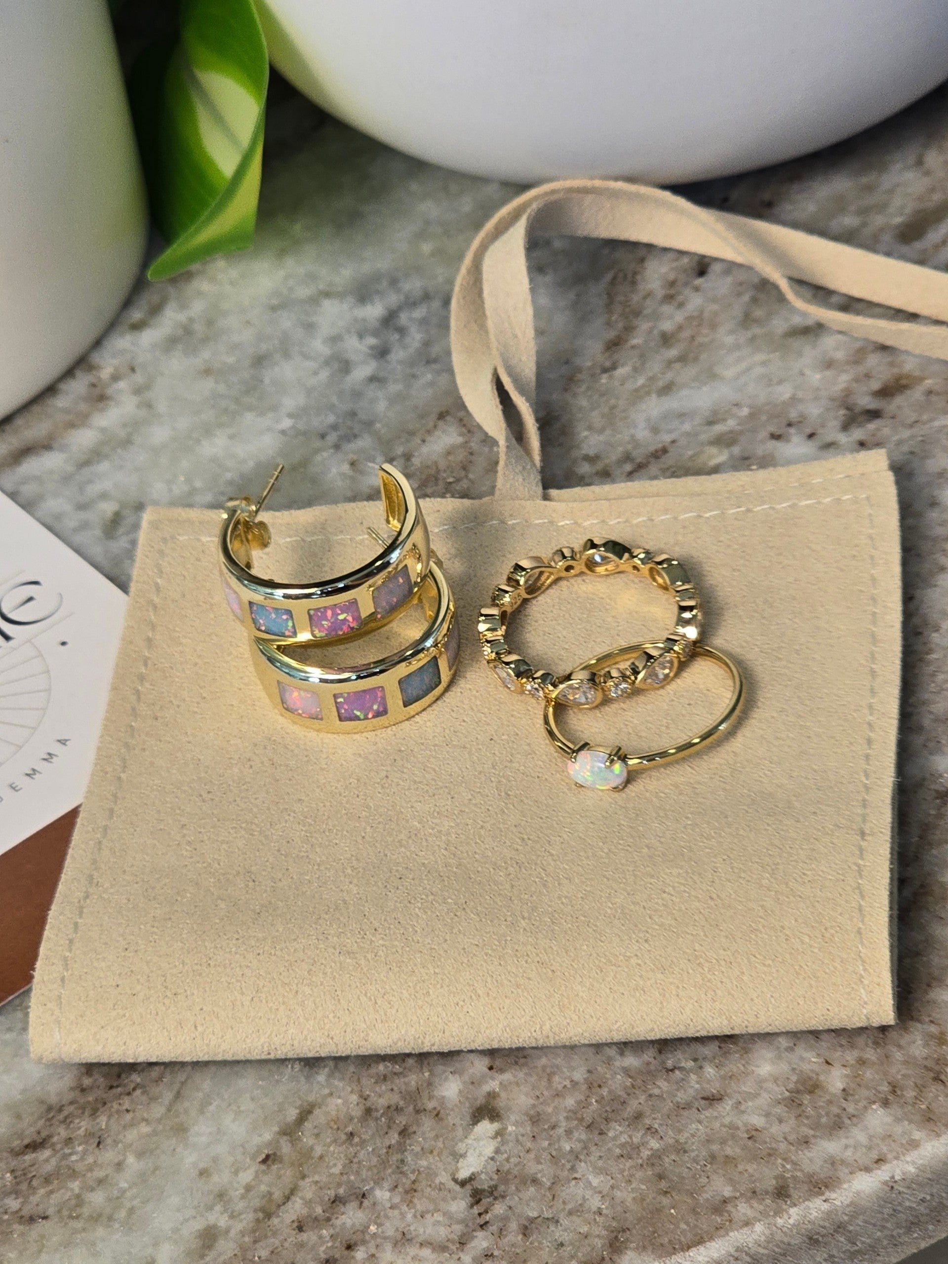 reveriebygemma opal ombre inlay gold vermeil hoop earrings with matching rings on a beige velvet pouch