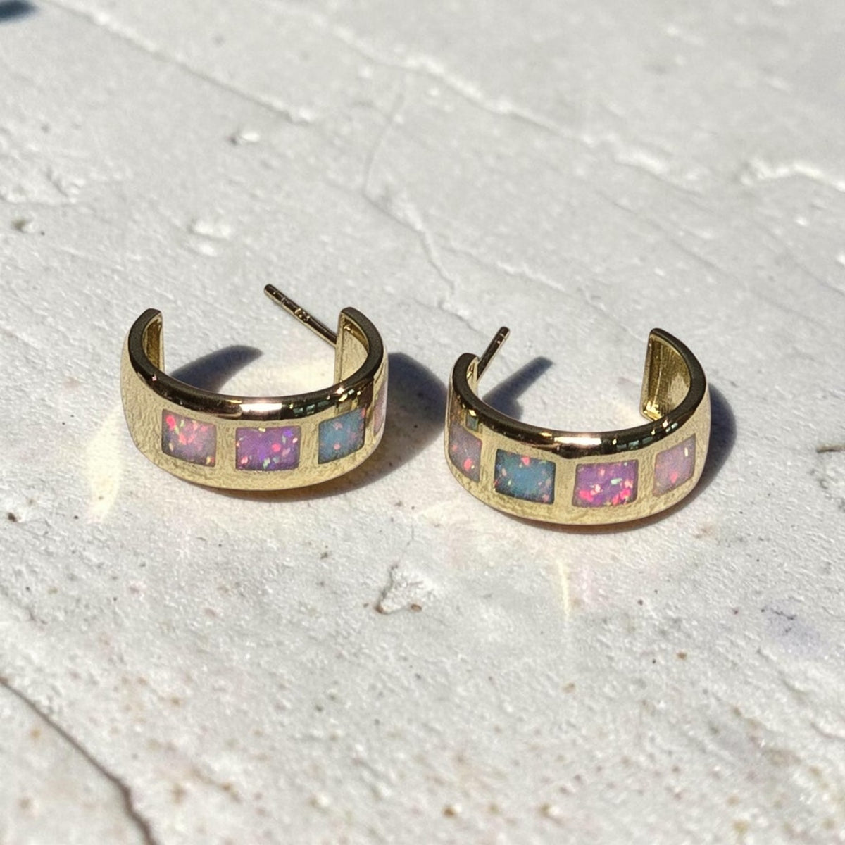 reveriebygemma 18kt gold vermeil hoop earrings with square-cut iridescent opal ombré inlay on a textured pastel surface.