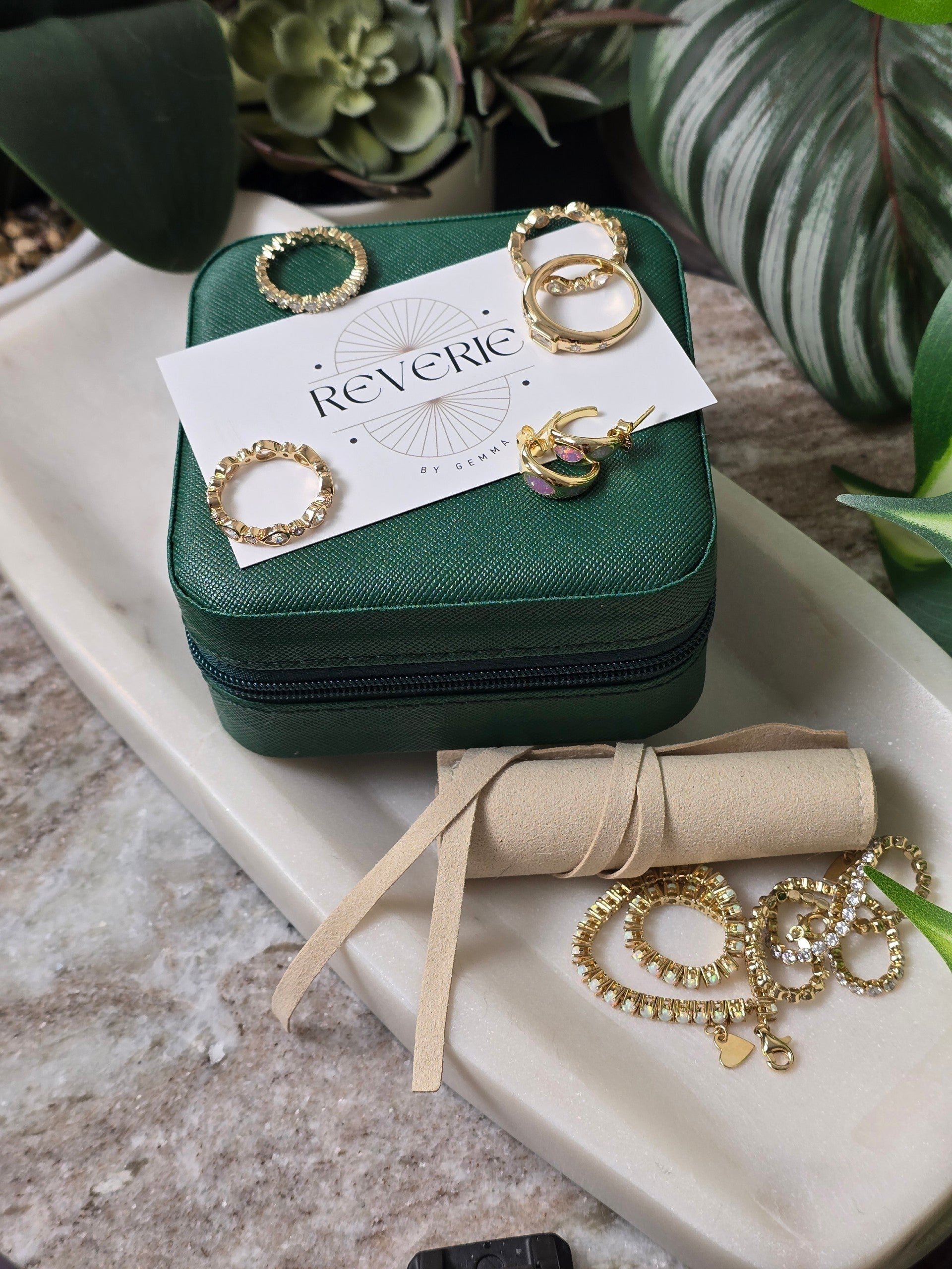 reveriebygemma Pear & Round Bezel Stacking Ring in gold plated silver with cubic zirconia on a green jewelry box